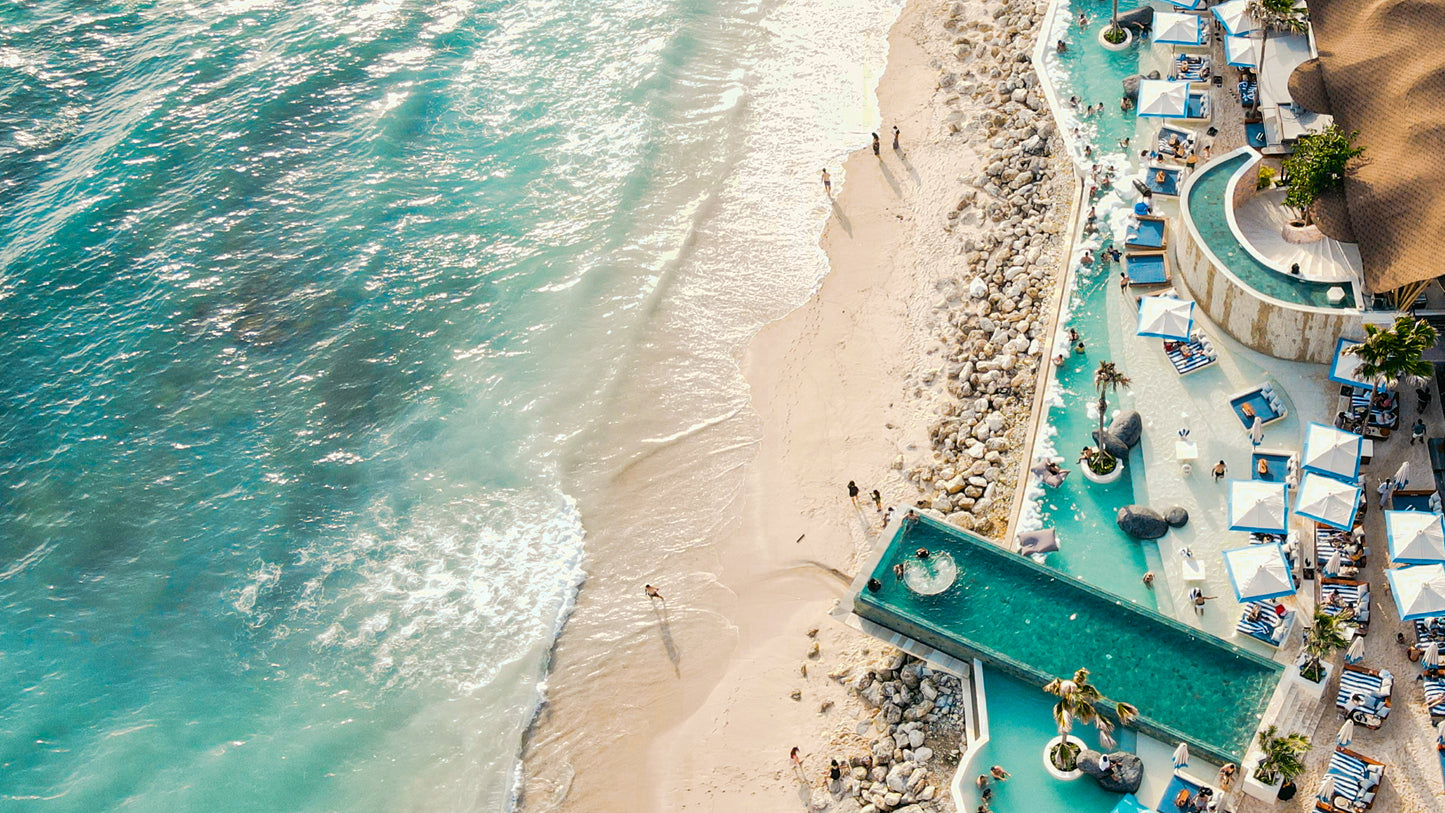 Tropical Temptation Beach Club in Bali Melasti Beach with white sand and crystal waters.